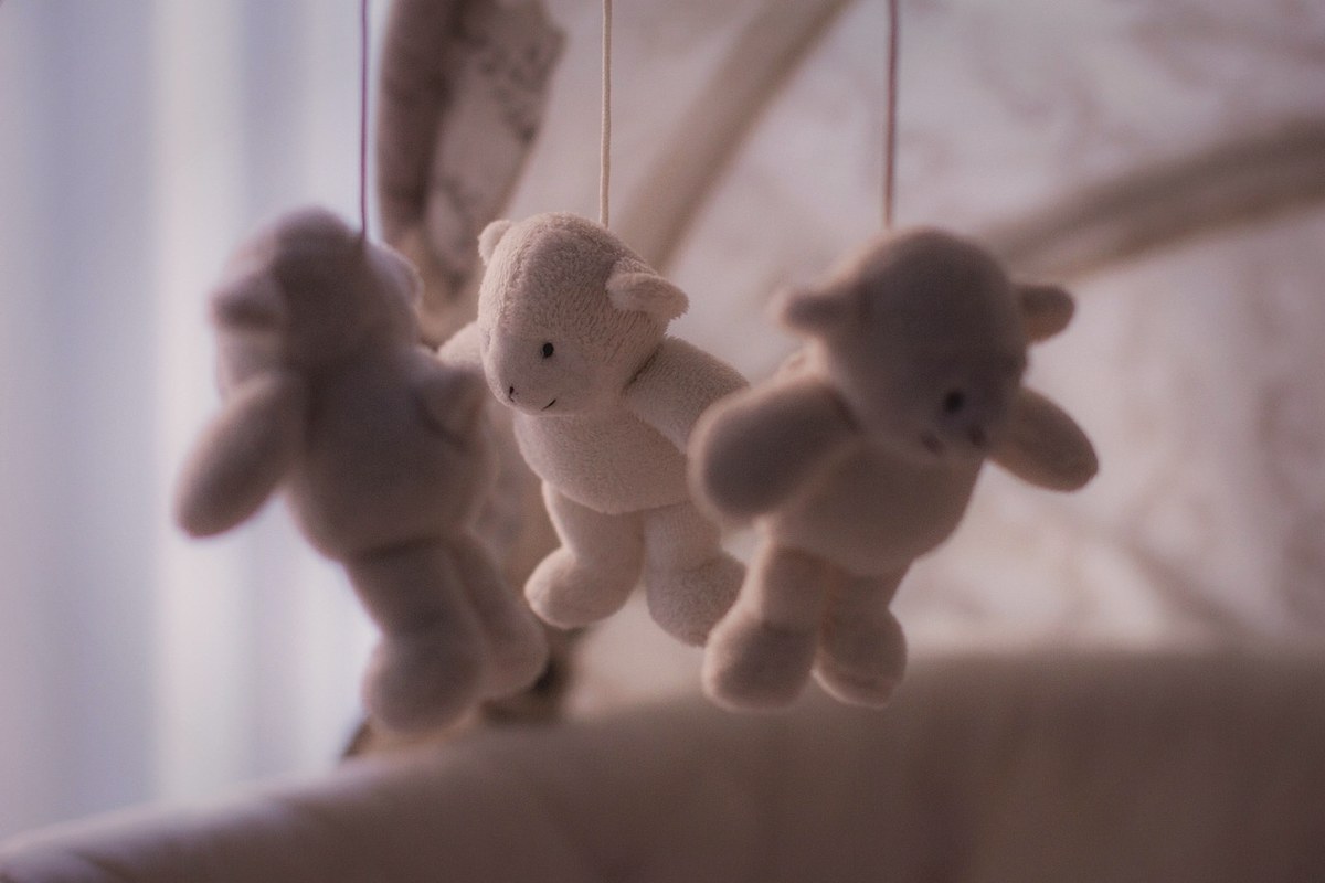 아기 침대 위에 매달린 곰 인형 모빌